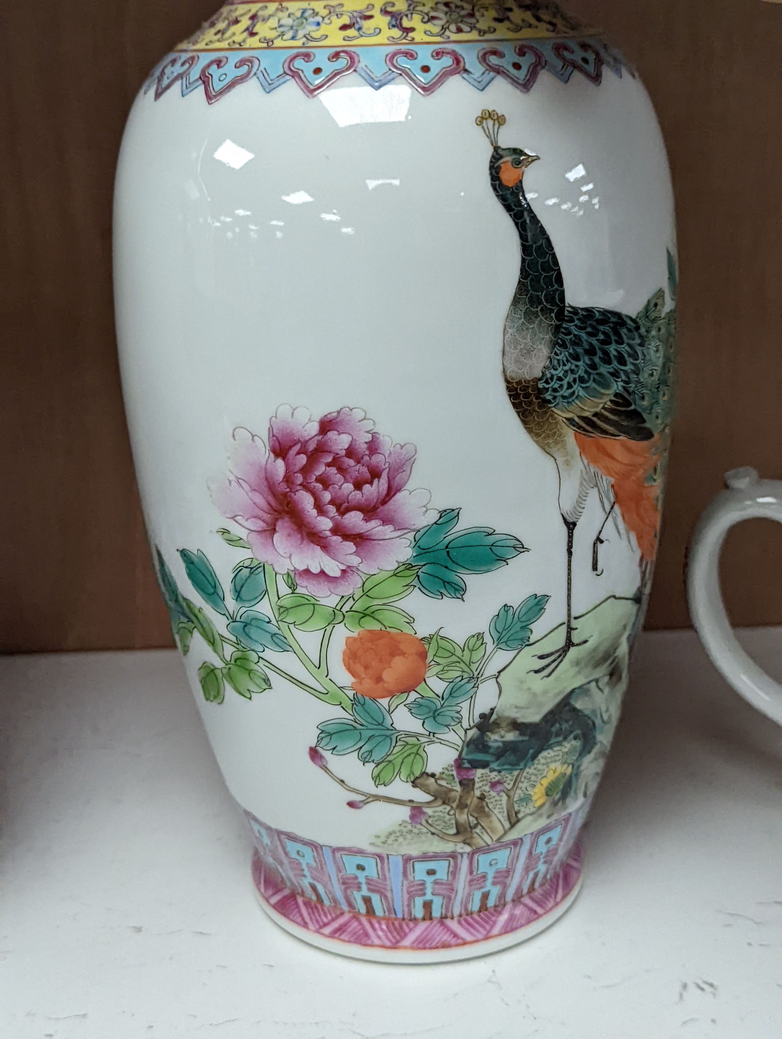 A pair of Chinese famille rose vases decorated with peacocks, 31cm